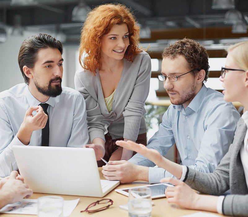Equipo profesional colaborando alrededor de una computadora